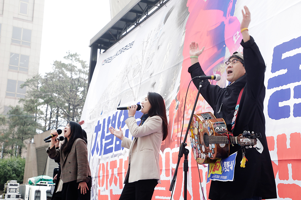 민중가수들이 3월 24일  ‘2022년 투쟁 선포 민주노총 단위노조 대표자 결의대회’에서 조합원들에게 힘을 주는 노래공연을 하고 있다. 신동준