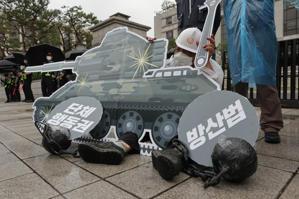 6월 15일 ‘방위산업사업장 노동자의 온전한 노동 3권 쟁취를 위한 기자회견’에 참가한 금속노동자가 방위산업체 노동자의 고통을 표현한 상징의식을 벌이고 있다. 김규백
