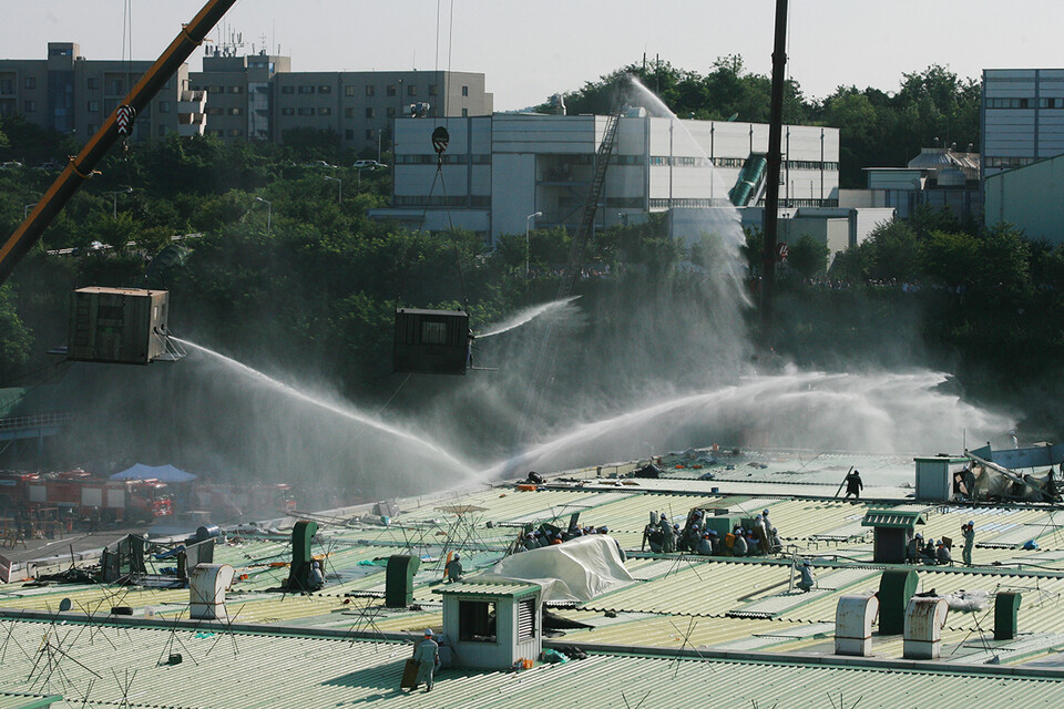 2009년 8월 5일 경찰이 공장 지붕에서 농성 중인 조합원들을 진압하기 위해 업체에서 대여한 기중기를 이용해 특공대를 투입하고 있다. 