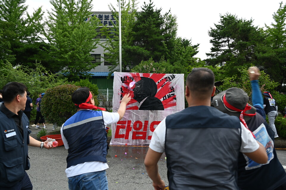 대회참가자들이 상징의식으로 회계공시,타임오프,윤석열퇴진이 적힌 벽면에 물풍선을 던지고 있다. 강연석